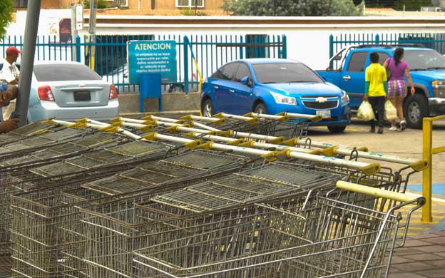 Desde las afueras de los supermercados los compradores se quejan por no poder adquirir los productos regulados en las tiendas privadas. (Foto: Alejandro Paredes)