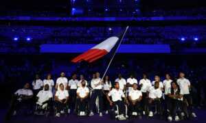 Atletas paralímpicos reciben la estafeta durante la clausura de París 2024