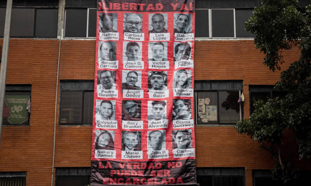 Encapuchados armados destruyen pancarta de periodistas detenidos en el CNP Caracas